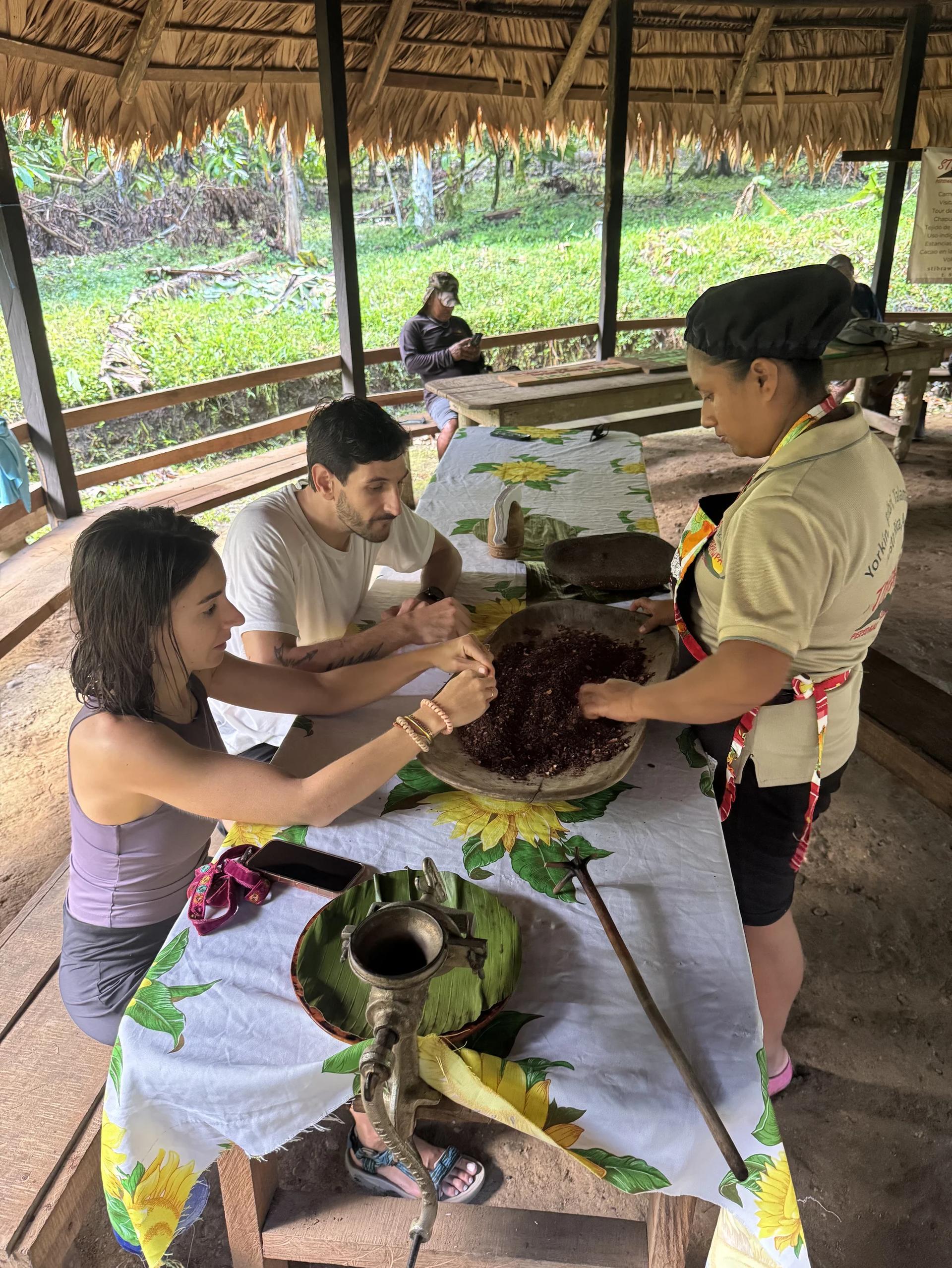 couple de voyageurs découvrant les fèves de cacao lors d'une démonstration en territoire bribri