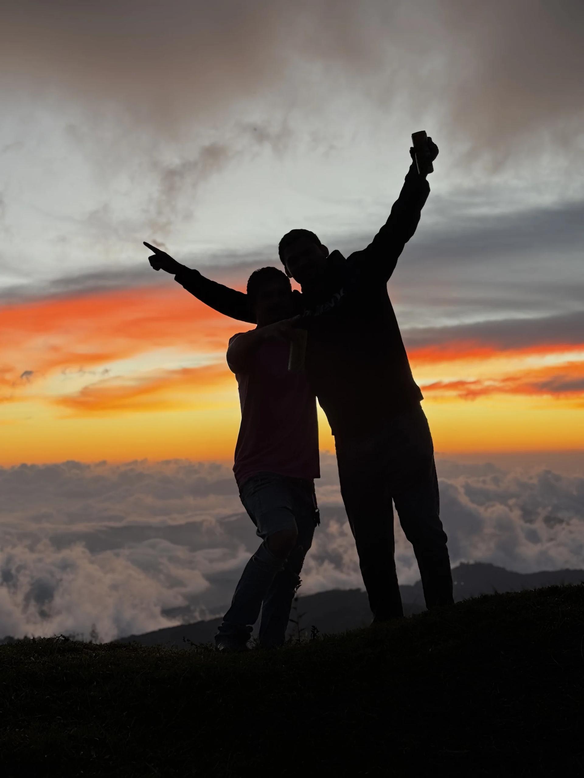 Coucher de soleil romantique avec les ombres d'un couple au dessus d'une mer de nuages