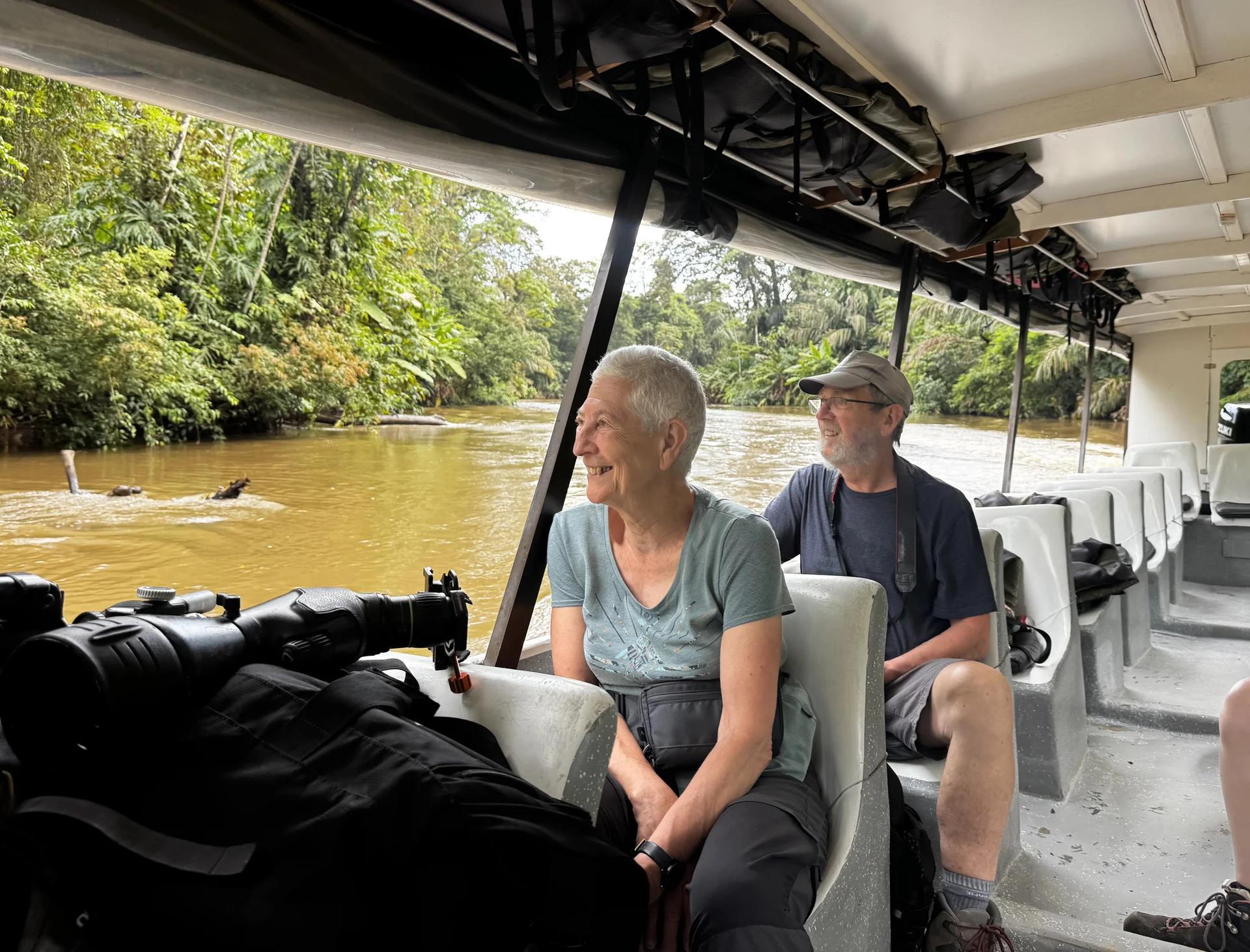 Deux voyageurs dans un bateau sur les canaux de tortuguero avec en premier plan de téléscope
