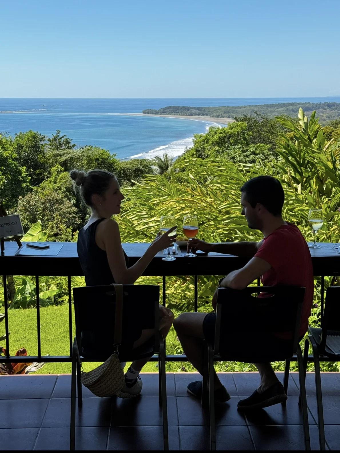 un couple trinquant pour leur voyage de noces au Costa Rica avec vue sur l'océan pacifique
