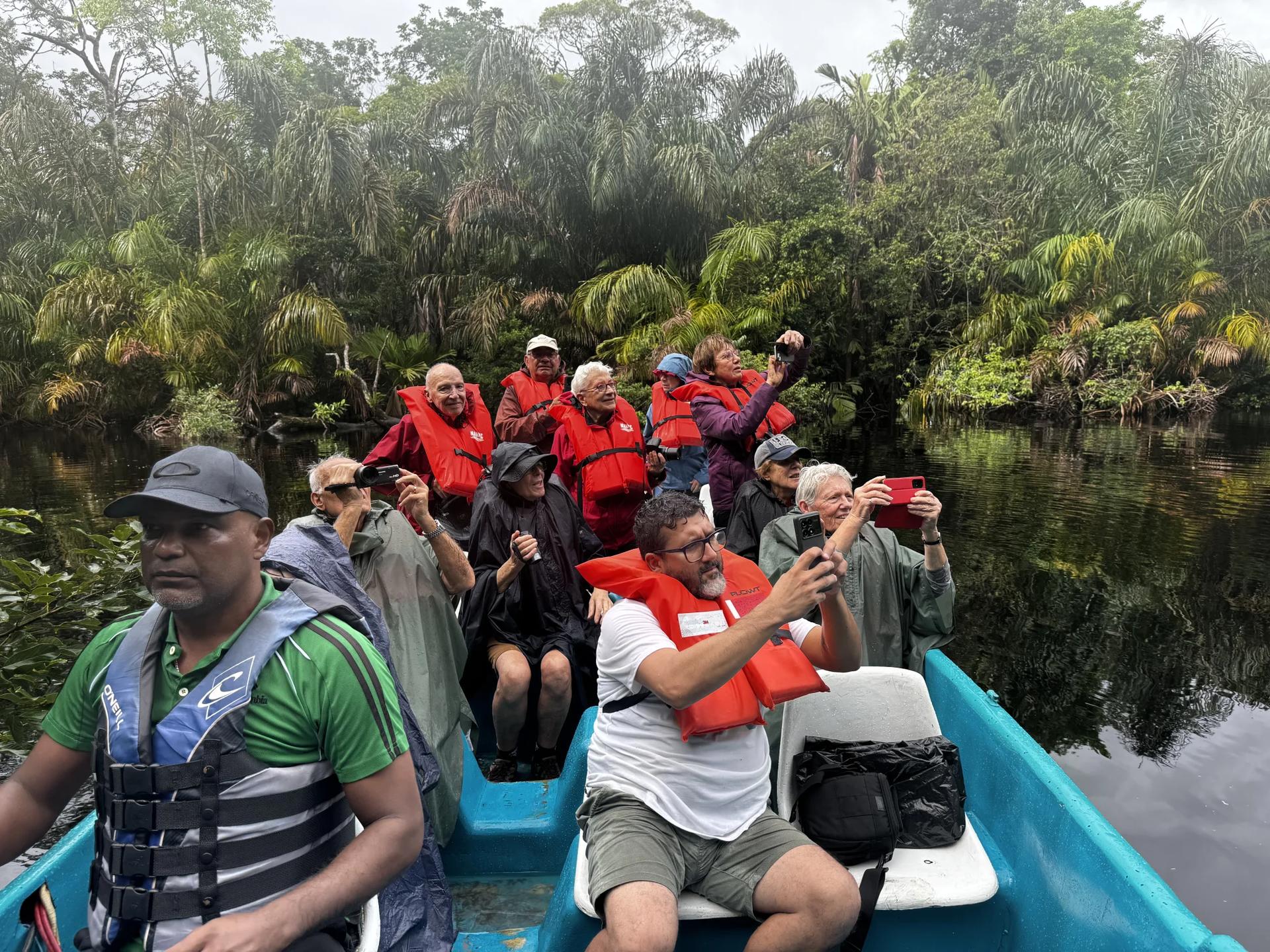 En bateau sur les canaux de Tortuguero avec un groupe de voyageurs souriant entrain de prendre une photo